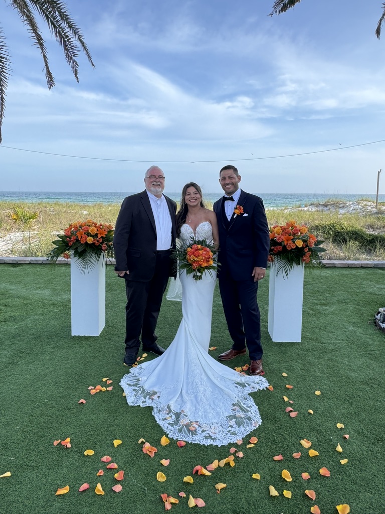 Doug with a couple under a garden pergola